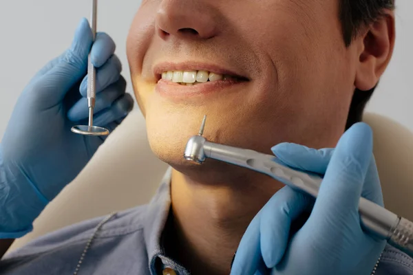 Przycięty Widok Dentysty Lateksowych Rękawiczkach Przyrządami Stomatologicznymi Pobliżu Wesołego Pacjenta — Zdjęcie stockowe