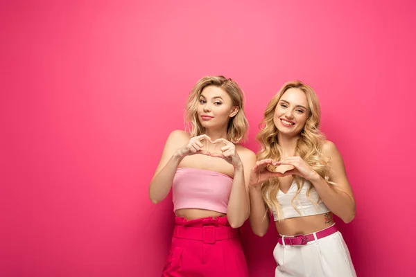 Glimlachende Blonde Vrouwen Tonen Liefde Teken Roze Achtergrond — Stockfoto