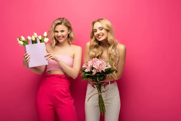 Vrolijke Blonde Meisjes Houden Boeketten Glimlachen Camera Roze Achtergrond — Stockfoto