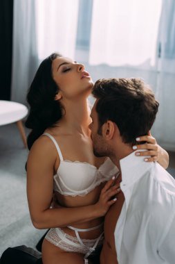 Yatak odasında iş adamını izleyen, gözleri kapalı seksi kız.