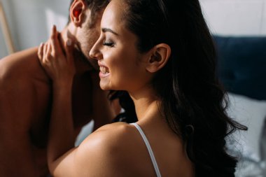 Kapalı gözlü, gülümseyen ve sarılan bir kız arkadaş.