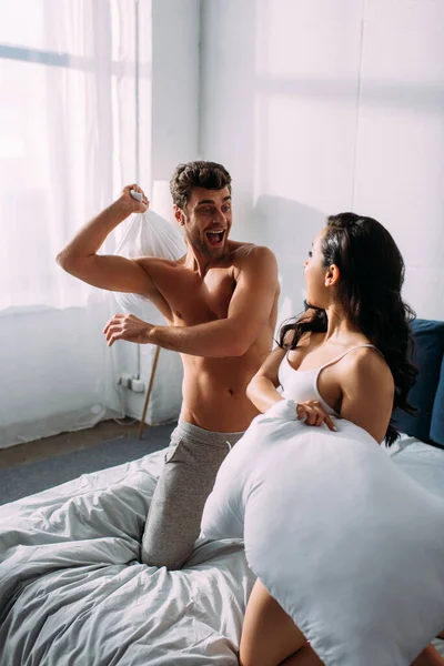 Excited Boyfriend Girlfriend Looking Each Other Fighting Pillows Bed Bedroom — Stock Photo, Image