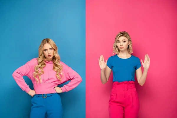 Blond Zusters Met Handen Heupen Tonen Stop Gebaar Roze Blauwe — Stockfoto