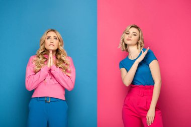Blonde girls showing shop and hope gestures on pink and blue background clipart