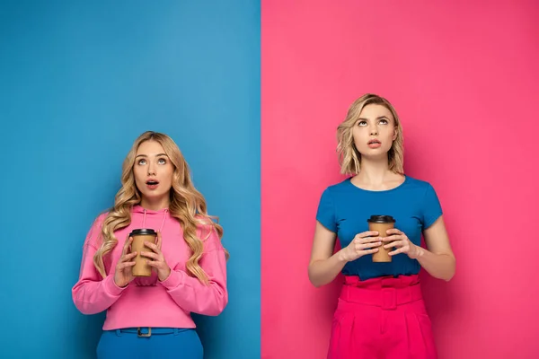 Shocked Blonde Sisters Disposable Cups Looking Pink Blue Background — Stock Photo, Image