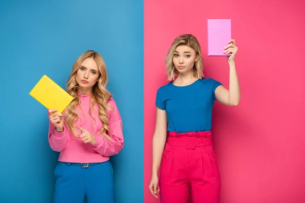 Blonde Girls Looking Camera While Holding Books Blue Pink Background — Stock Photo, Image
