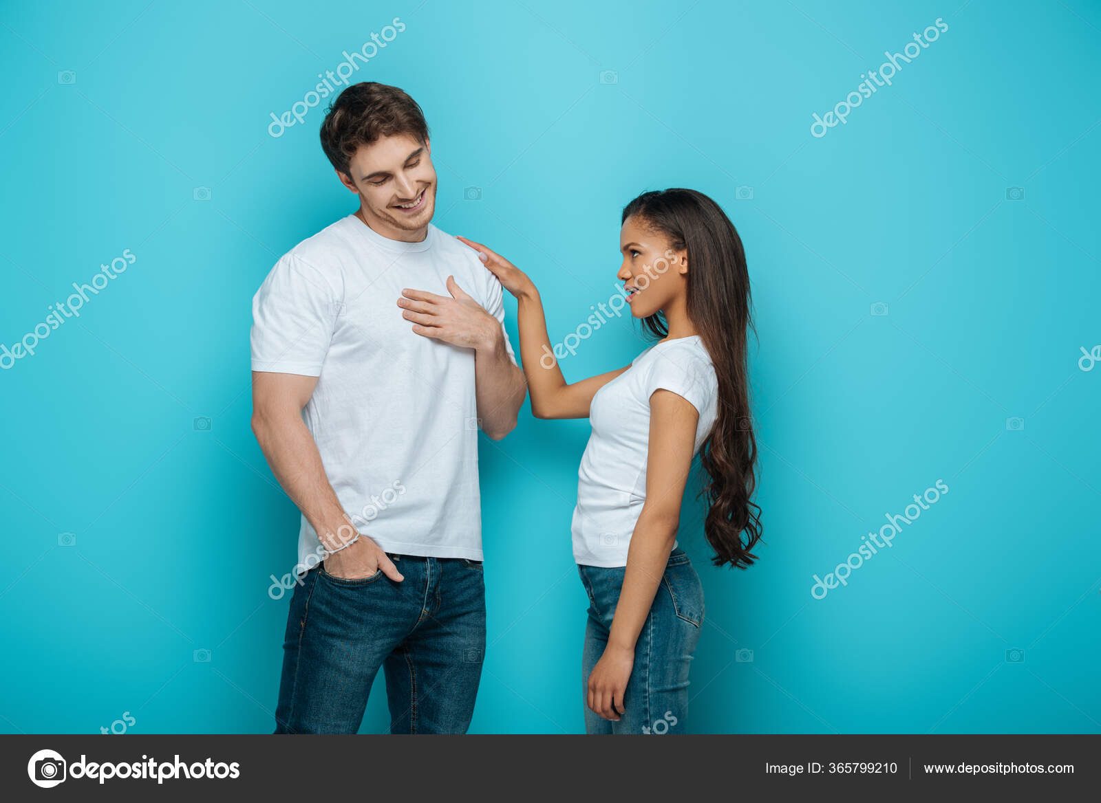 Shy Young Man Holding Hand Chest While African American Girl Stock