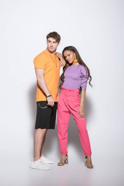 Beyaz arka planda yakışıklı erkek arkadaşının omzuna yaslanan afro-amerikan kızına uzun bir bakış açısı