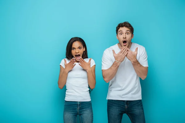 Shocked Interracial Couple Holding Hands Faces Open Mouths While Looking — Stock Photo, Image