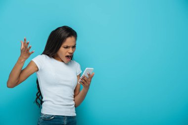 Sinirli Afrikalı Amerikalı kız, mavi hattan izole edilmiş akıllı telefondan video görüşmesi sırasında çığlık atıyor.