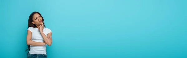 Горизонтальне Зображення Афроамериканської Дівчини Яка Торкається Підборіддя Дивлячись Ізольовано Синьому — стокове фото
