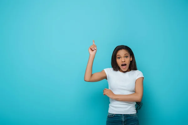 Shocked African American Girl Looking Camera While Pointing Finger Blue — Stock Photo, Image