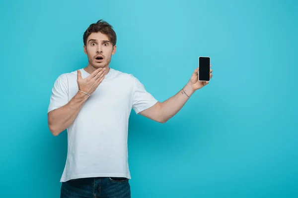 Cara Chocado Segurando Mão Perto Rosto Mostrar Smartphone Com Tela — Fotografia de Stock