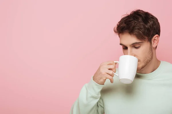 Yakışıklı Genç Adam Pembe Bardakta Beyaz Fincandan Kahve Içiyor — Stok fotoğraf