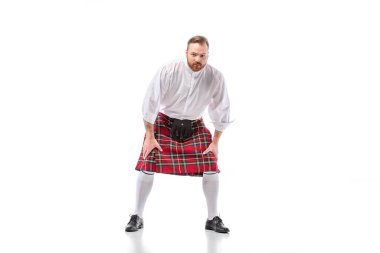 Scottish redhead man in red kilt in pose on white background clipart