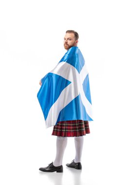 back view of Scottish redhead man in red kilt with flag of Scotland on white background clipart