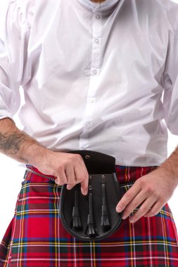 Kırmızılı İskoç adamın deri kemer çantasına dokunuşunun görüntüsü beyaza izole edilmiş.