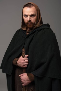 ciddi ortaçağ İskoç kızıl saçlı adam şömine rafında gri arka planda