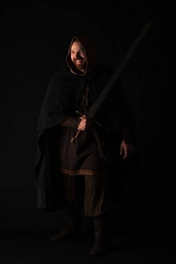 Ortaçağ İskoç kızıl saçlı mutlu bir adam. Şömine rafında, kılıçlı, siyah üzerine izole edilmiş bir adam.