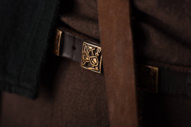close up view of medieval Scottish brown clothing and belt with golden buckle clipart