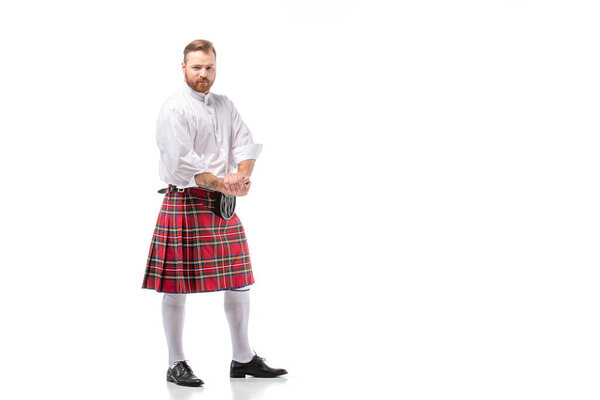 Шотландский рыжий мужчина в красном килте на белом фоне

