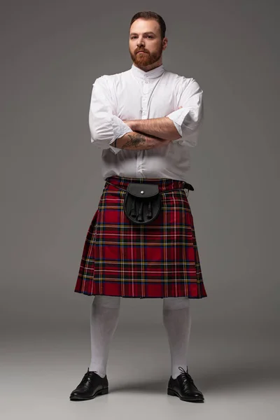 Escocês Ruiva Homem Kilt Vermelho Com Braços Cruzados Fundo Cinza — Fotografia de Stock