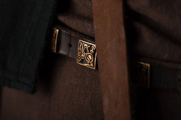 close up view of medieval Scottish brown clothing and belt with golden buckle