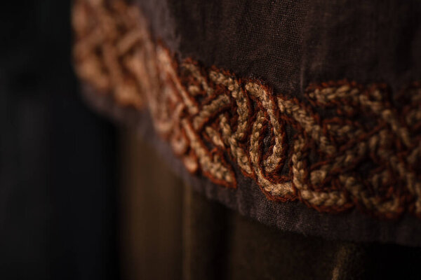close up view of medieval Scottish brown clothing with embroidery