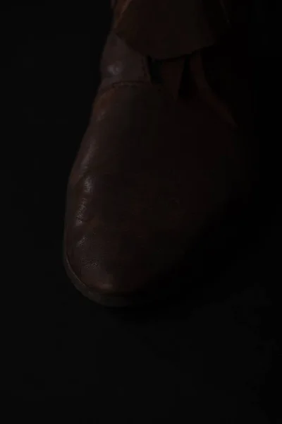 close up view of medieval Scottish brown leather shoes isolated on black