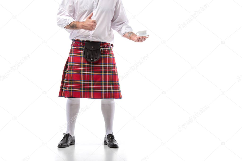 cropped view of Scottish man in red kilt and knee socks with coffee showing thumb up on white background