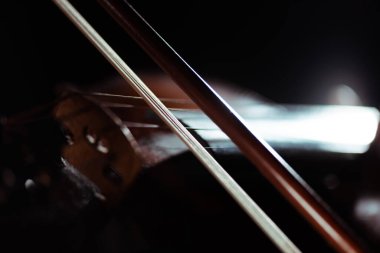 close up of violin and bow in dark, selective focus clipart