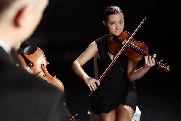 在黑暗舞台上用小提琴演奏古典音乐的专业女音乐家 — 图库照片