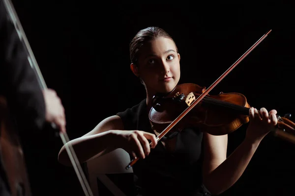 在黑暗舞台上演奏小提琴和低音的专业音乐家 — 图库照片