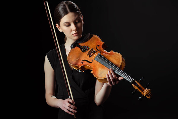 beautiful musician playing symphony on violin isolated on black