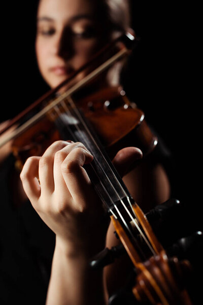 selective focus of female musician playing symphony on violin isolated on black