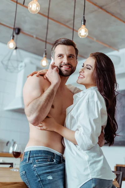 Happy Woman Hugging Sexy Shirtless Boyfriend While Man Talking Smartphone — Stock Photo, Image