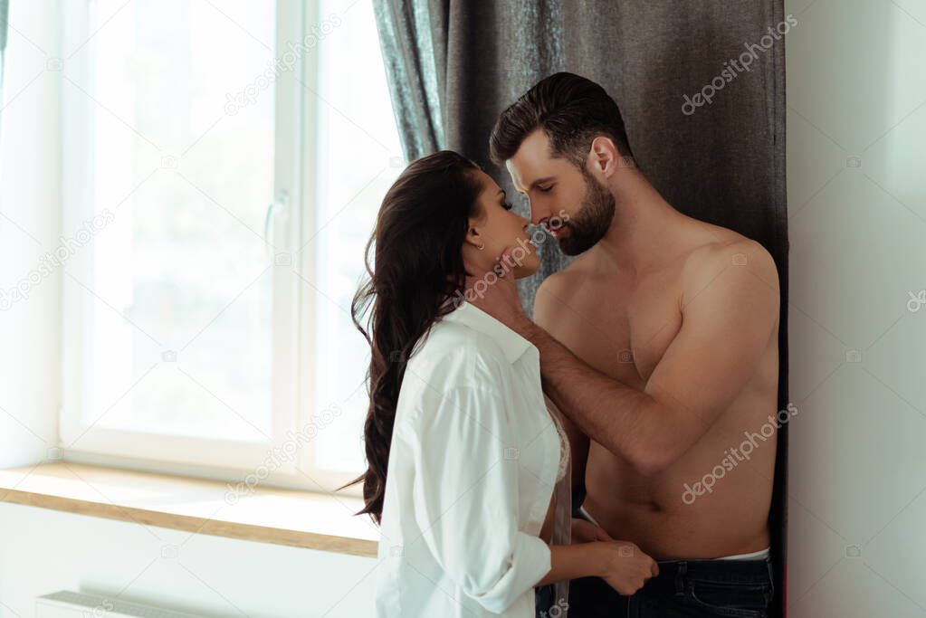 sexy couple kissing at home near window