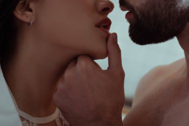 Erkeğin, genç ve seksi bir kadının dudaklarına dokunuşunu yakından izle.