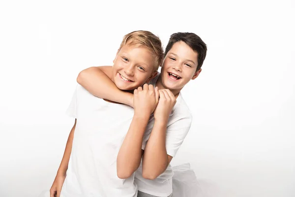 Cheerful boy jokingly stifling smiling brother isolated on white — Stock Photo