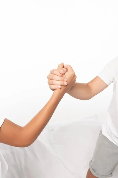 Cropped view of boys holding hands isolated on white — Stock Photo