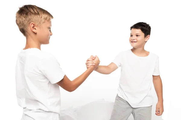 Smiling brothers holding hands isolated on white — Stock Photo