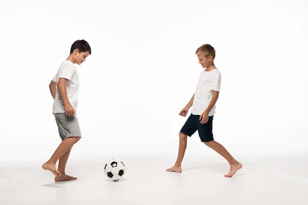 Two brothers in pajamas playing football on white background — Stock Photo