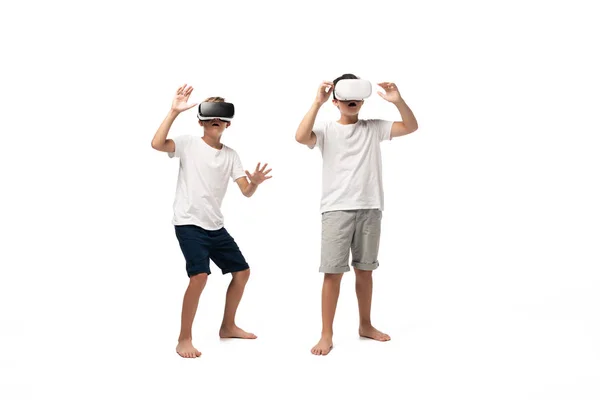 Two scared brothers gesturing while using vr headsets on white background — Stock Photo