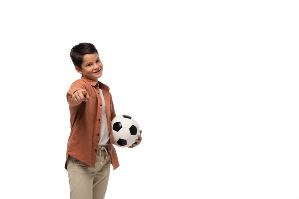 Fröhlicher Junge hält Fußballball und zeigt mit dem Finger auf Kamera isoliert auf weiß — Stockfoto