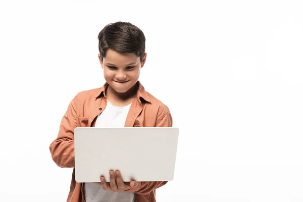 Concentrated boy using laptop while standing isolated on white — Stock Photo