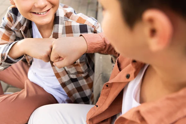 Recortado vista de sonriente chico haciendo puño golpe con hermano - foto de stock