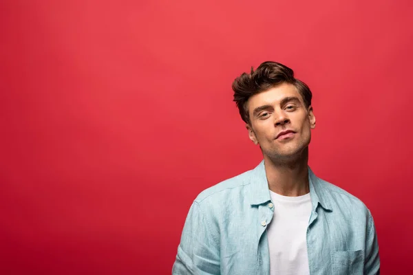 Portrait of handsome smiling man in casual clothes isolated on red — Stock Photo