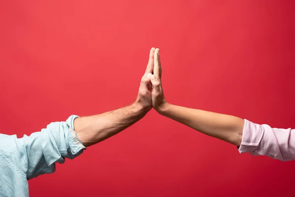 Vista parcial de pareja dando cinco alto, aislado en rojo - foto de stock