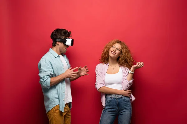 Schönes glückliches Paar in vr-Headset, isoliert auf rot — Stockfoto