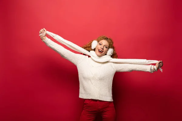 Красива весела жінка позує в зимовому вбранні ізольована на червоному — стокове фото